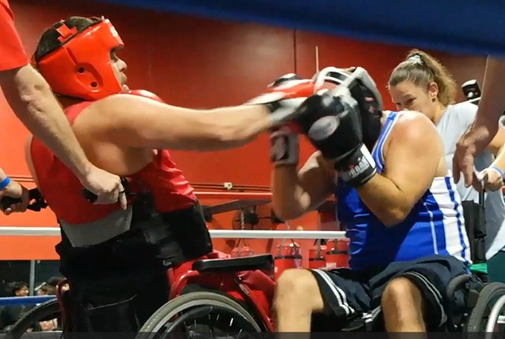 Two wheelchair boxers sparring in the ring